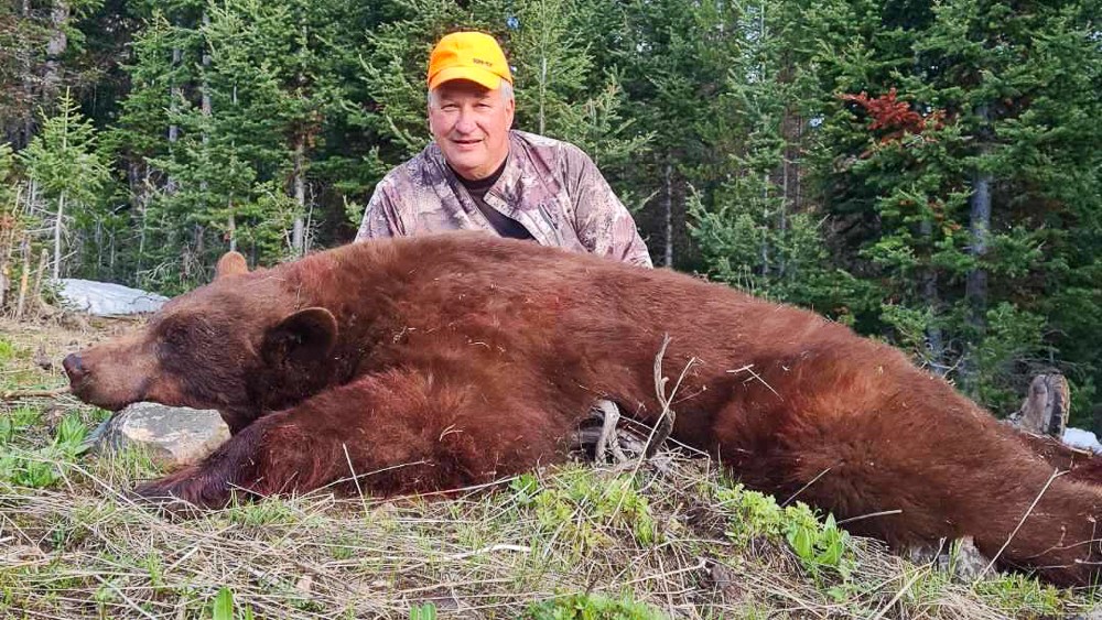 hunter poses with his Wyoming black bear